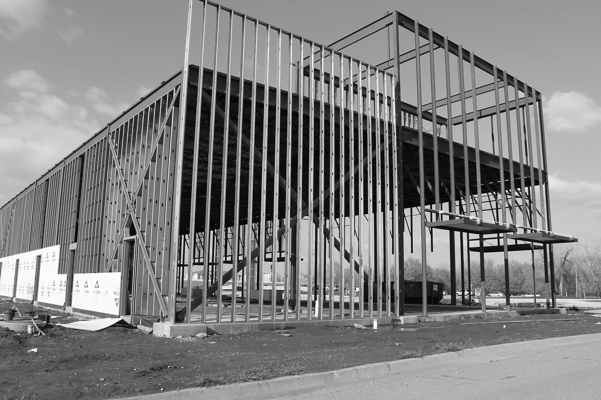 Black and white photo of a multi-story steel building frame under construction